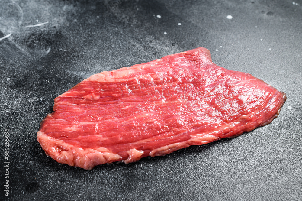 Raw flank steak. Marble beef black Angus. Black background. Top view