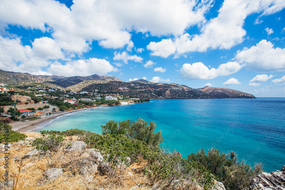 
Coast of a greek island in the mediterranean sea. A bay with beautiful blue clear water, with a beach, on a background of mountains.