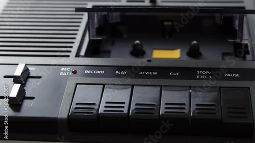 Eject white audio cassette from black cassette player. Close-up shot. Male hands
