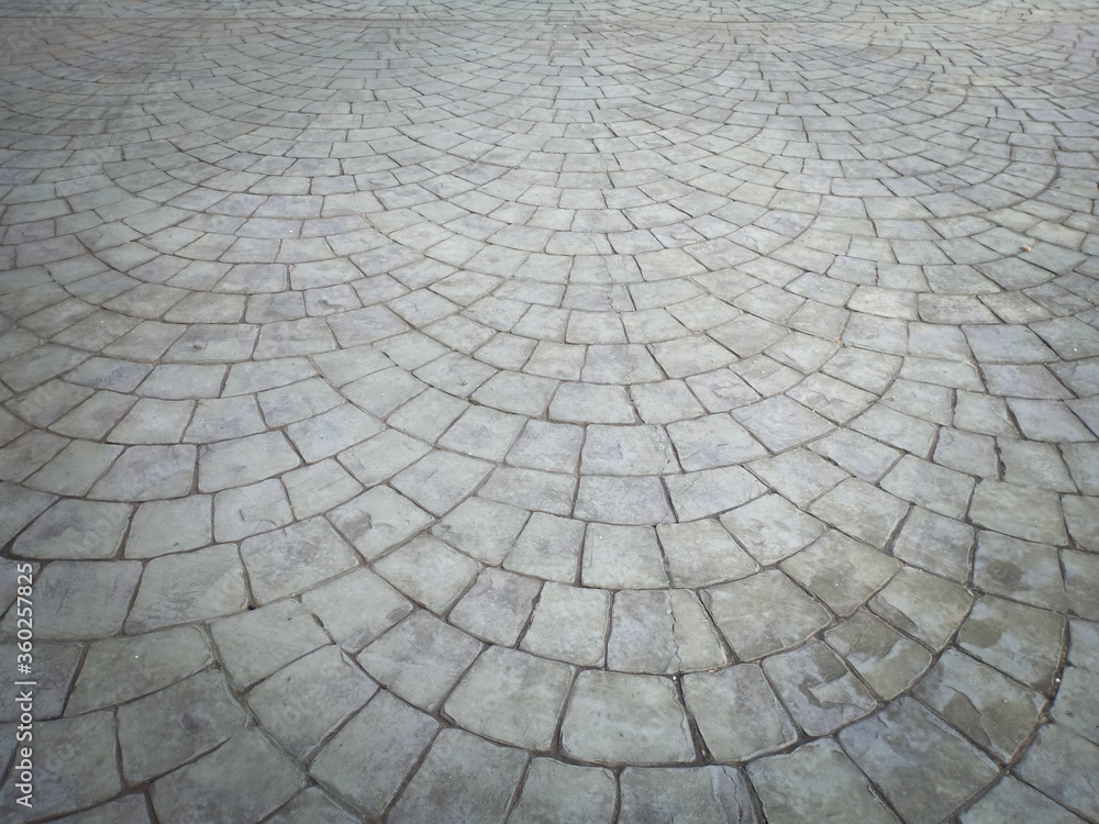 Gray cobblestone bricks floor with a curve of half-circle pattern as background texture. - obrazy, fototapety, plakaty 