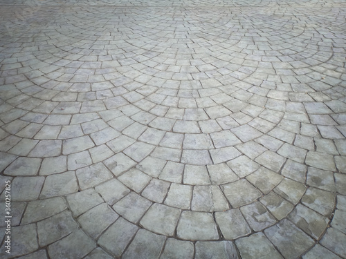 Gray cobblestone bricks floor with a curve of half-circle pattern as background texture.