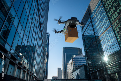Drone delivering package between highrise buildings, London, UK
