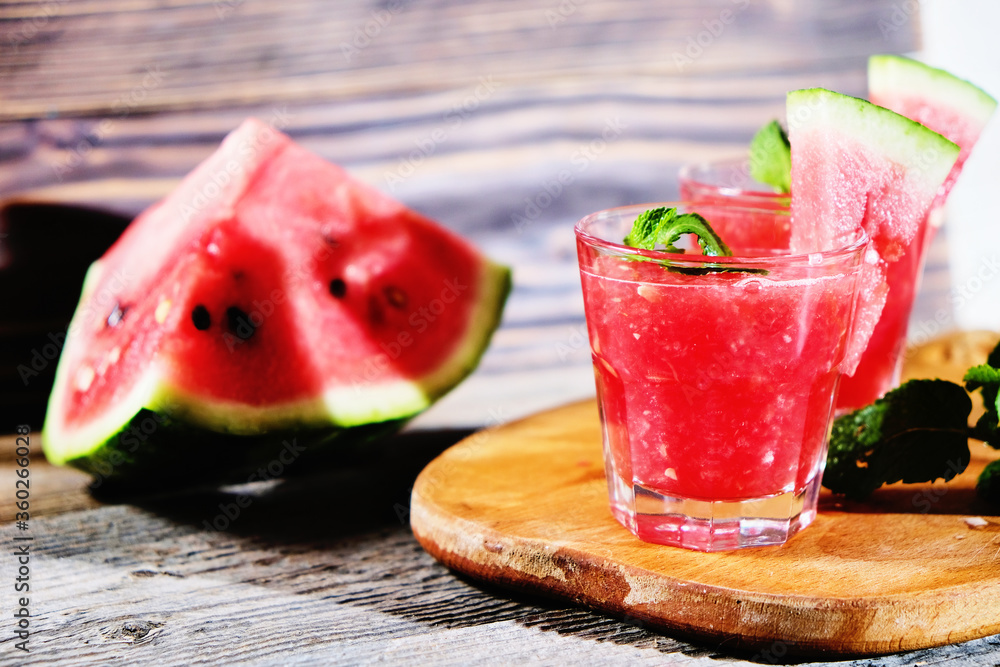 Watermelon Mojito with Watermelon Garnish on wooden table Watermelon Mojito with Watermelon Garnish on wooden table