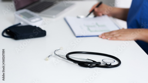 Medical doctor taking notes in clinic or hospital.