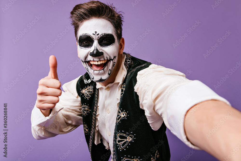 Happy european guy with traditional mexican body art posing on purple  background. Stylish man with zombie makeup making selfie. foto de Stock |  Adobe Stock