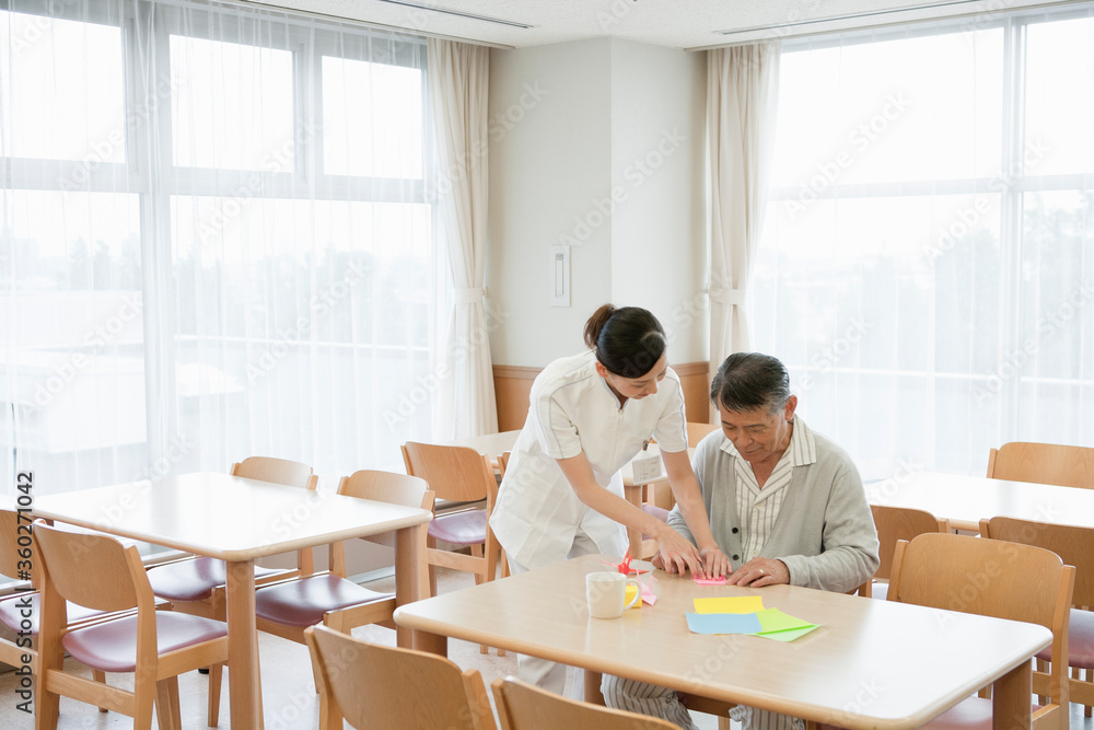 看護師と折り紙をする入院患者 看護師と折り紙をする入院患者