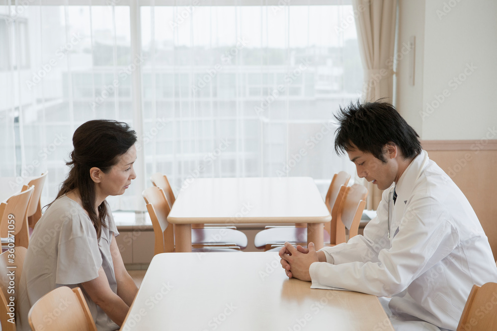 医師の話を聞く患者の家族 医師の話を聞く患者の家族