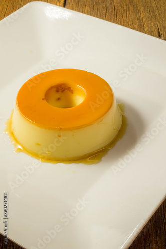 Milk Pudding or Pudim de leite. Brazilian dessert homemade caramel custard pudding. Traditional brazilian flan on wooden background.