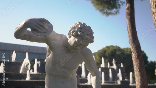 A close-up footage of white statue in the background of decorative fountain with flowing water. 