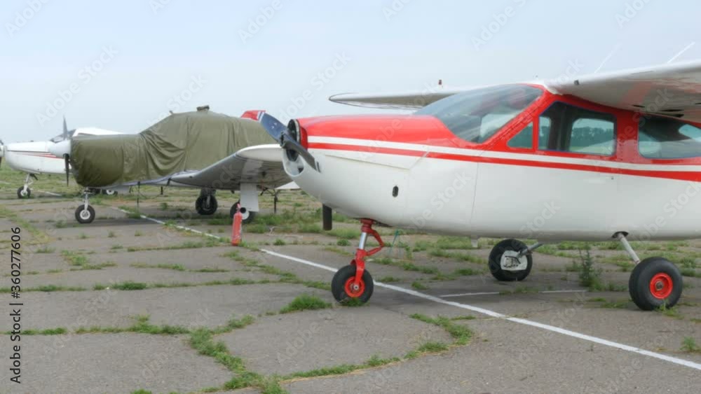 A number of small passenger aircraft stand at the airport. A number of small passenger aircraft stand at the airport.