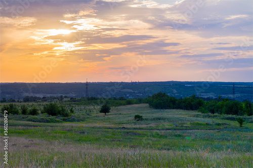 sunset in the cloudy sky above the industrial city