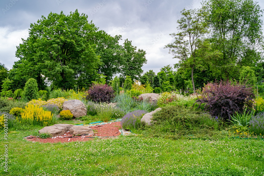 Gardening landscape and landscaping design as a perennial garden lawn with a flowerbed and ornamental plants in a decorative landscaped pathway. Gardening landscape and landscaping design as a perennial garden lawn with a flowerbed and ornamental plants in a decorative landscaped pathway.