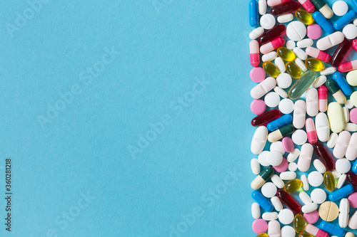 Different types of medication, tablets, capsules on blue background