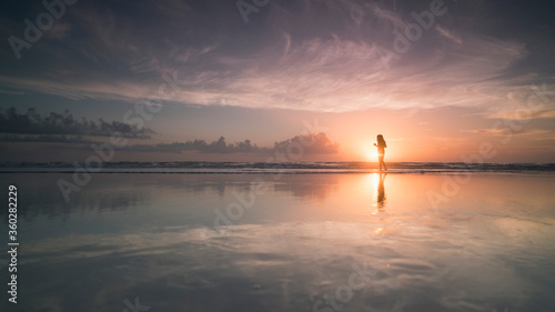Silhouette woman at sea shore against cloudy sky during sunset, Daytona, Florida, USA photo
