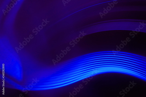 Close-up abstract image of vibrant blue light trails against black background photo