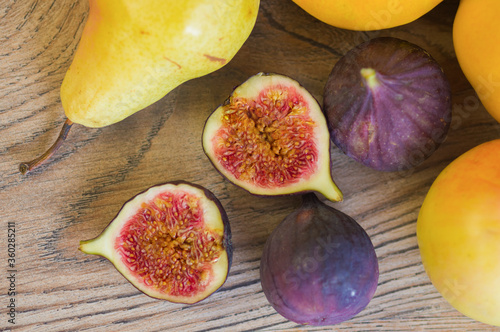 Ripe, juicy figs and pear on a wooden background. View from above