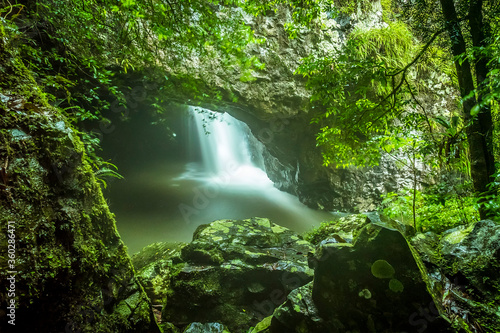 The entrance to Natural Bridge in Springbrook National Park  Queensland viewed from a rocky vantage point