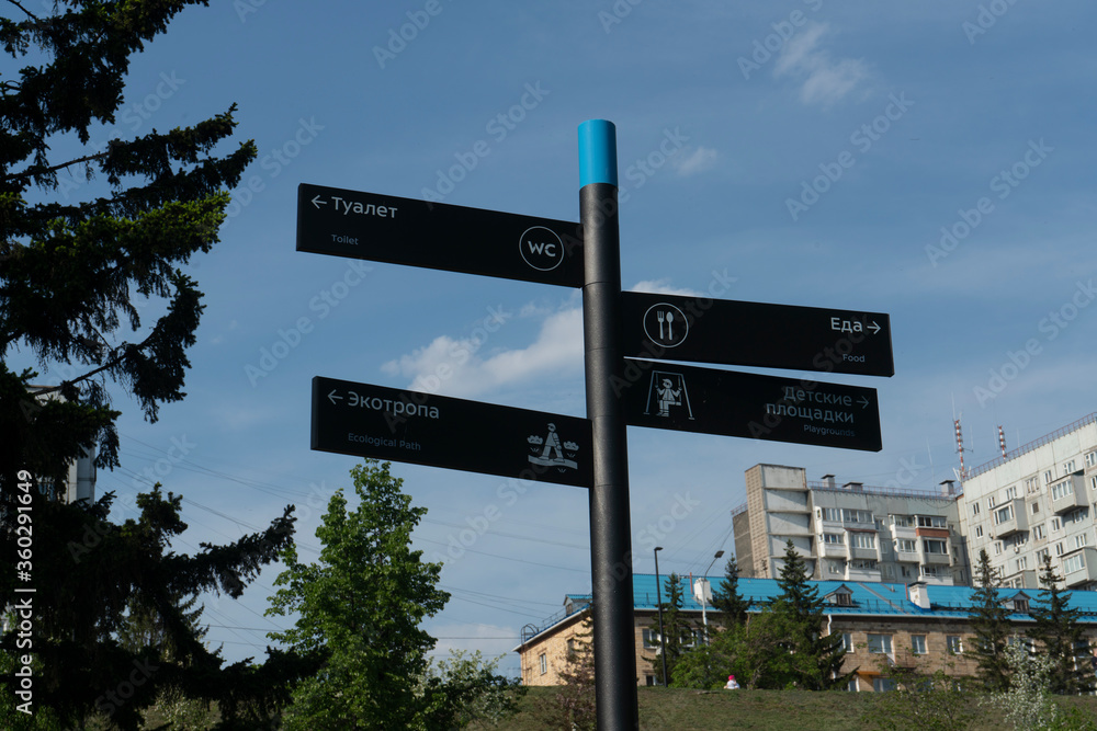 Fototapeta premium Gray post direction indicator in the park. Indicate Toilet, Playground, Ecotropic, Food.