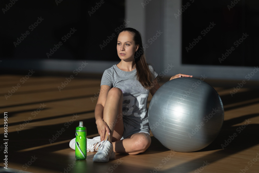 Pretty sexual straight fitness woman with musculat body lying on big ball in sport hall training indoor, horizontal picture Pretty sexual straight fitness woman with musculat body lying on big ball in sport hall training indoor, horizontal picture