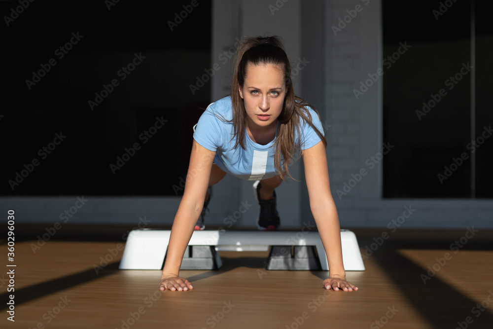 Girl doing push-ups in the gym, strength training Girl doing push-ups in the gym, strength training