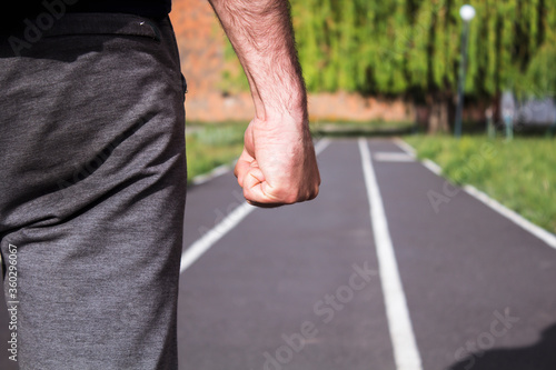a man with a fist on a running road