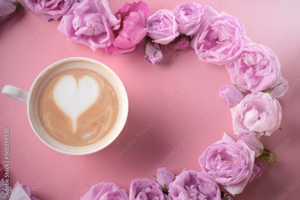 cup of coffee around may roses against pink background. romantic and beauty concept cup of coffee around may roses against pink background. romantic and beauty concept