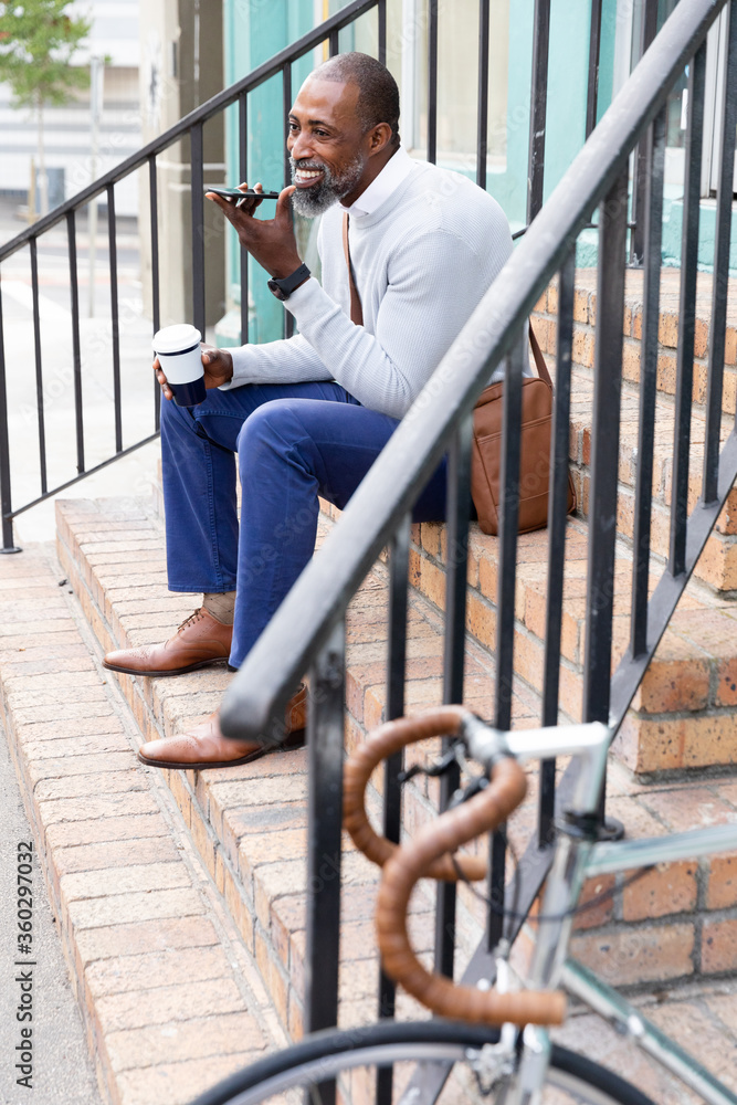 African American man sitting on stairs and having a phone call African American man sitting on stairs and having a phone call