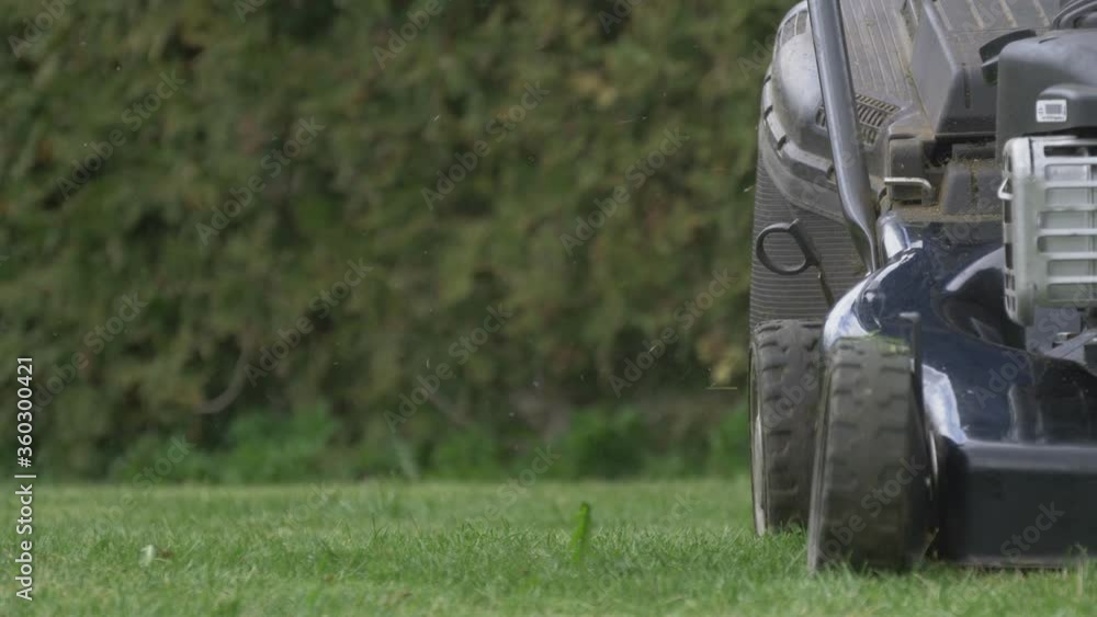 A Man Starts Self-Propelled Gasoline Lawn Mower and Cuts The Grass. 4K Slow-Motion Footage A Man Starts Self-Propelled Gasoline Lawn Mower and Cuts The Grass. 4K Slow-Motion Footage
