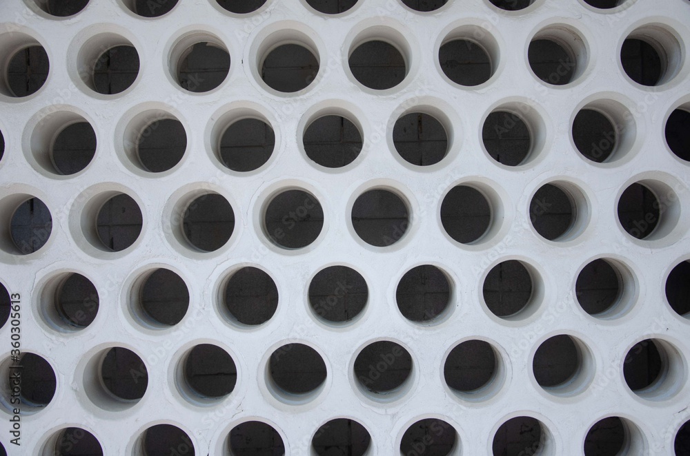 Concrete wall with holes, many geometric holes in the wall background
Concrete wall with holes, many geometric holes in the wall background