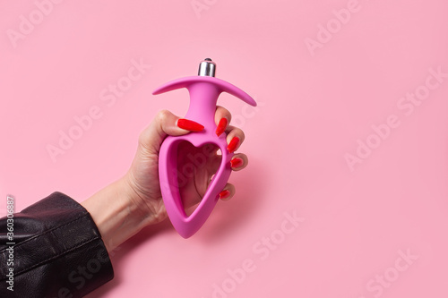 Adult toy, Dildo in hand on a pink background photo