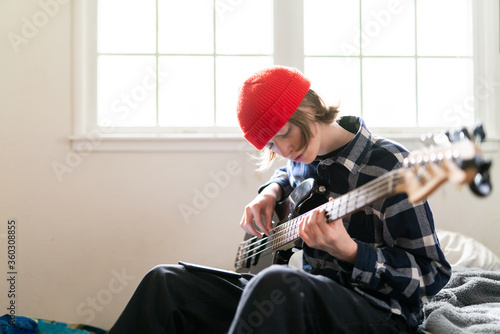 High school student working at home on learning guitar for homework photo