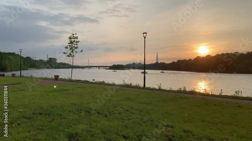Russia, St.Petersburg, 10 June 2020: The boat with a wakesurfer on a wave goes down the river at sunset, bridge, skyscraper on background, Lakhta center