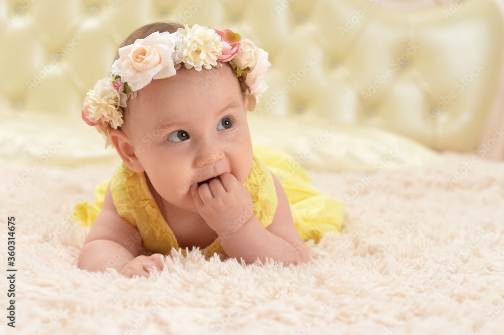 Cute little baby girl in wreath on bed Cute little baby girl in wreath on bed