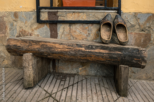 Fotografie Typical rural wooden shoes from Asturias over a wooden bench