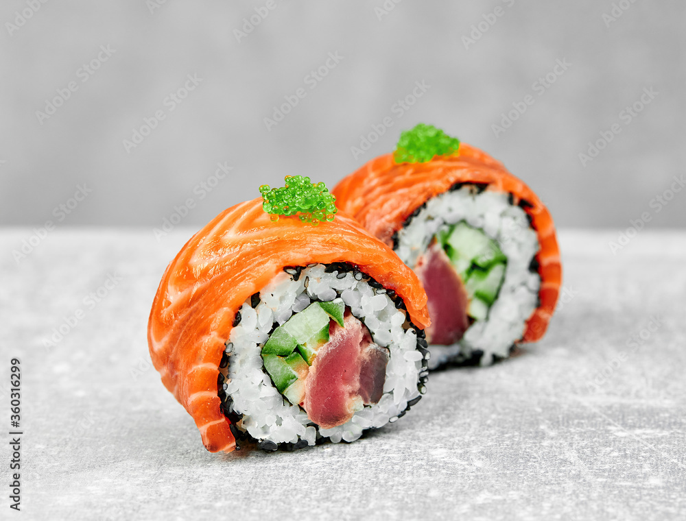 2 slices of non-classical Philadelphia sushi with salmon, tuna, cucumber and garnished with green caviar 2 slices of non-classical Philadelphia sushi with salmon, tuna, cucumber and garnished with green caviar