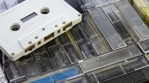 Male hand put down white audio cassette on a set of audio cassettes in cases