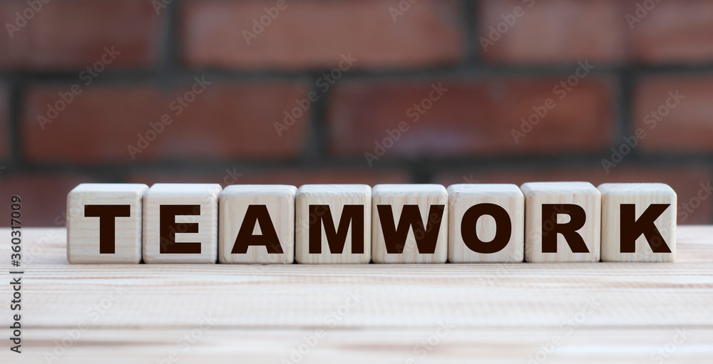 Obraz premium concept word TEAMWORK on cubes against the background of a brick wall