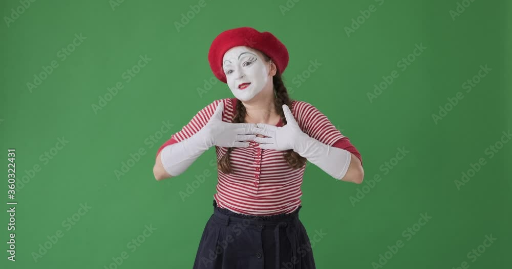 Female mime artist greeting by waving hand and gesturing flying kiss towards her fans from the stage Female mime artist greeting by waving hand and gesturing flying kiss towards her fans from the stage