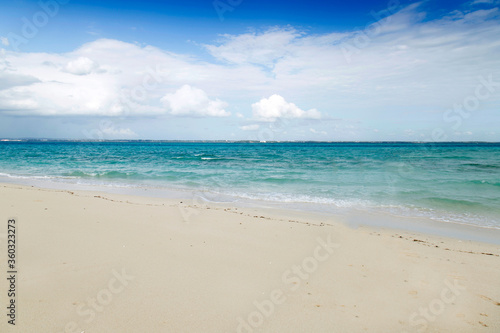 Fototapeta Naklejka Na Ścianę i Meble -  Clean white sand beach with turquoise water . Tropical island background. Small waves crushing on the beach. Clean empty white sand beach on Maldives island 