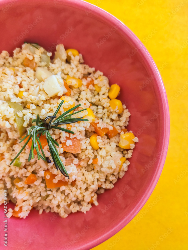 bowl of whole grain salad with yellow background with rosemary bowl of whole grain salad with yellow background with rosemary