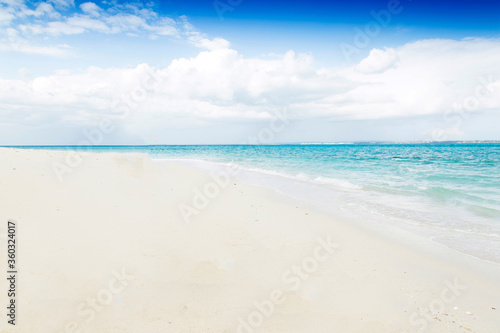 Clean white sand beach with turquoise water . Tropical island background. Small waves crushing on the beach. Clean empty white sand beach on Zanzibar. Paradise beach