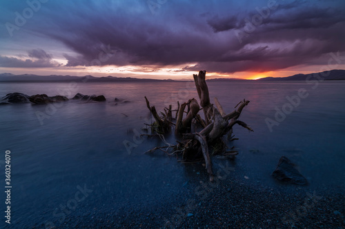 Beautiful sunset landscape. Old stump in the lake on the after rain. Sevan lake Armenia. © Inga Av