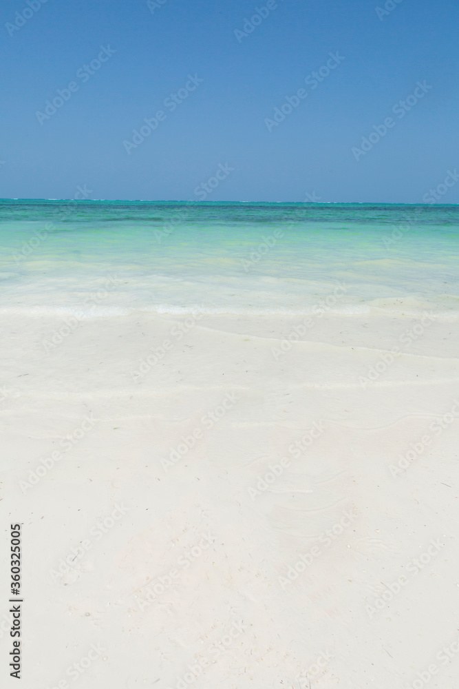 Clean white sand beach with turquoise water . Tropical island background. Small waves crushing on the beach. untouched beach 