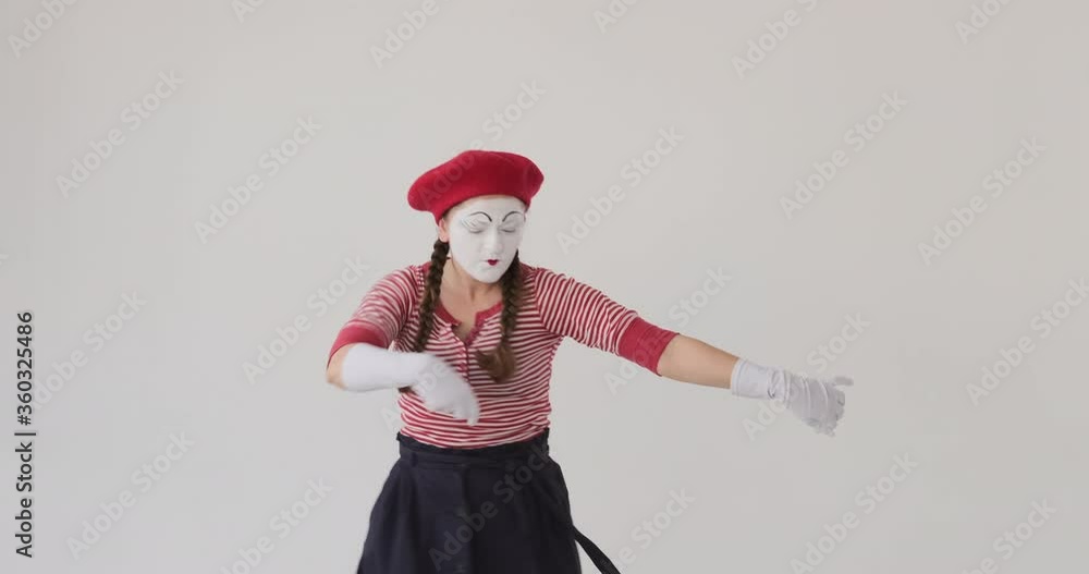 Female mime artist performing dance moves over white background Female mime artist performing dance moves over white background