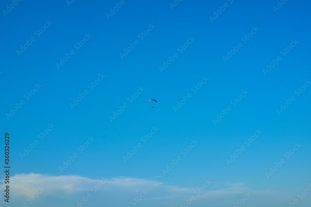 Fototapeta premium Hang glider with engine over blue sky