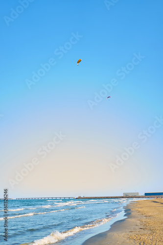 Hang glider with engine over blue sky
