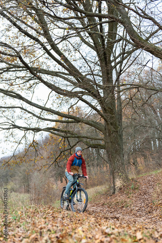 man rides a bicycle on nature at high speed in autumn