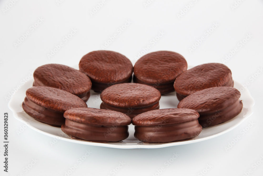 chocolate-coated cookies on a plate, isolate on a white background chocolate-coated cookies on a plate, isolate on a white background