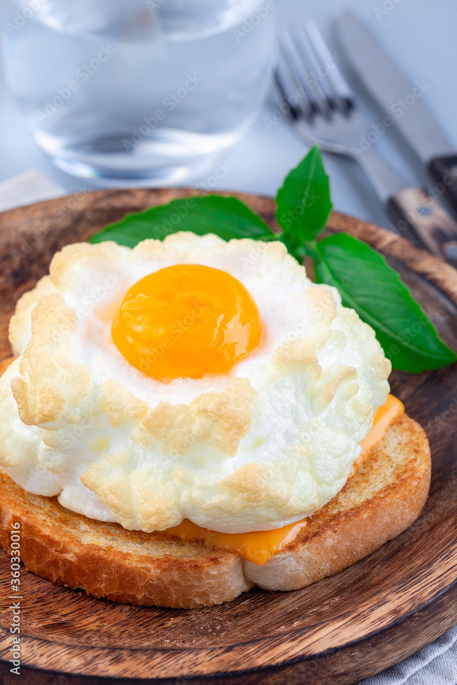 Trendy cloud or fluffy egg dish on wooden plate, vertical Trendy cloud or fluffy egg dish on wooden plate, vertical