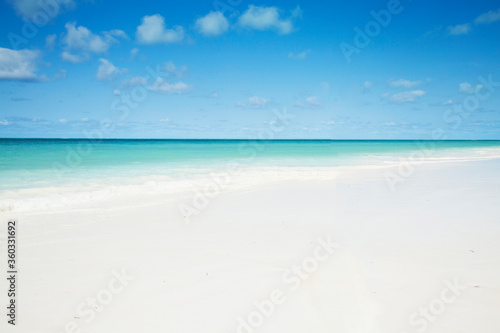 Fototapeta Naklejka Na Ścianę i Meble -  Clean white sand beach with turquoise water . Tropical island background. Small waves crushing on the beach.  Zanzibar island 